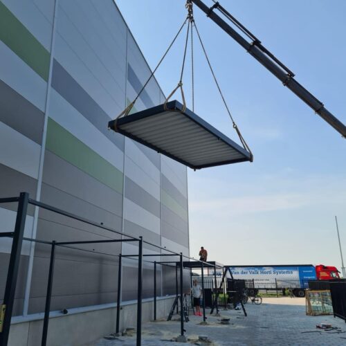 Fietsoverkapping Manheim - Modern en Maatwerk 86 Montage van fietsoverkapping Mannheim 20 meter waarbij het dak met een kraan op de constructie wordt geplaatst in Roosendaal
